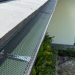 Mesh gutter guard running the length of a gutter